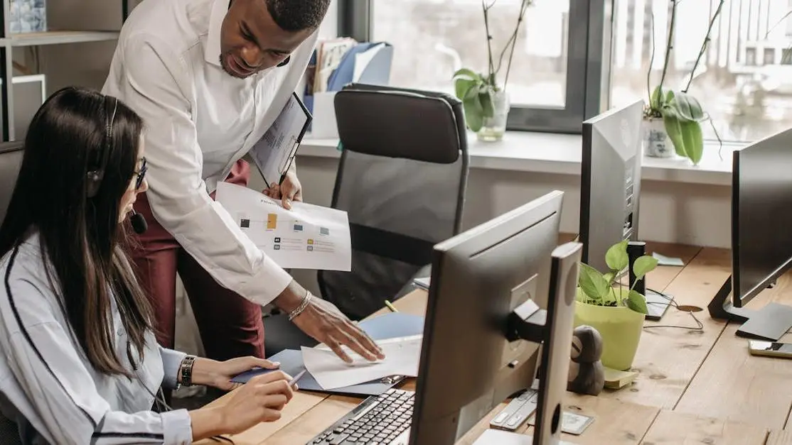 Twee jongeren volgen DJ-lessen voor jongeren achter een laptop in een moderne, lichte studioomgeving